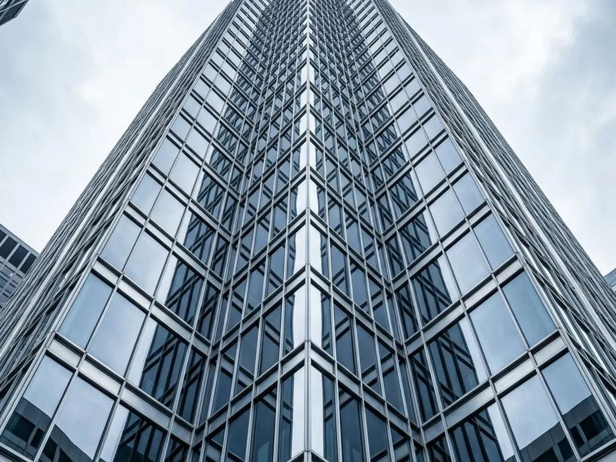 Looking up at a glass and steel commercial office tower in downtown Chicago